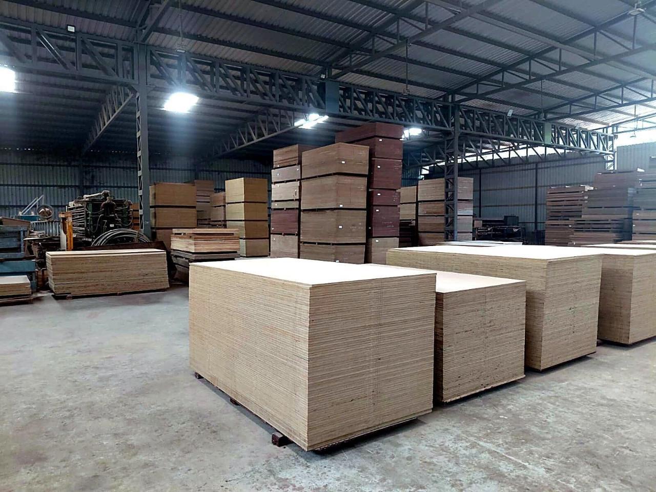 Warehouse aisle stacked with plywood and a forklift