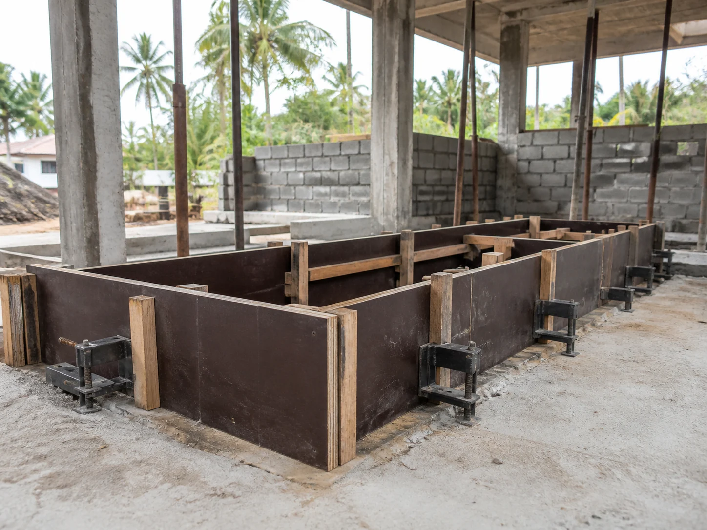 Plywood formwork panels supported by timber battens at a tropical construction site